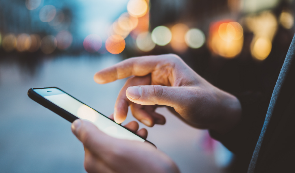 スマートフォンと、スマートフォンを操作する手